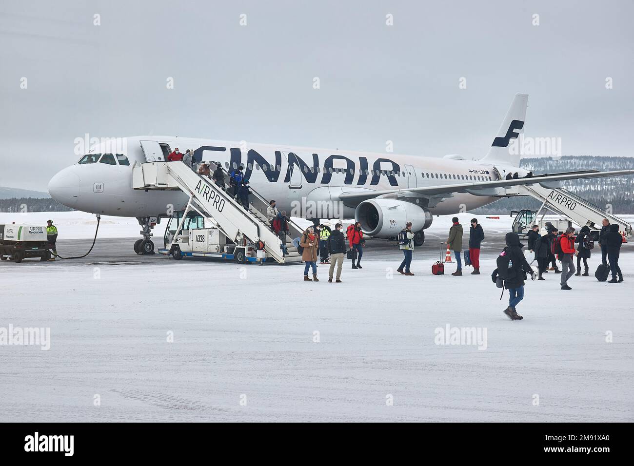 Les passagers d'un avion Finnair quittent la neige à leur arrivée Banque D'Images