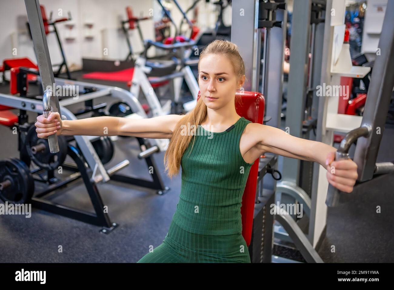 Une jeune femme s'entraîner sur un équipement de fitness à la salle de gym. Concept de santé, de sport et d'entraînement Banque D'Images
