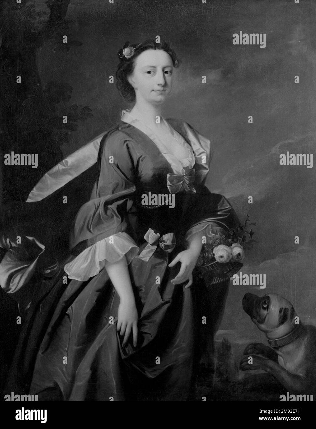 Mme John Wendt est attribuée à Thomas Hudson (britannique, 1701-1779). Mme John Wendt, ca. 1745. Huile sur toile, 50 1/4 x 39 7/8 in. (127,6 x 101,3 cm). Au milieu du XVIIIe siècle, Thomas Hudson a contribué à établir la norme pour les portraits à la mode à Londres avec des œuvres comme celle-ci. Le sitter est posé avec élégance, tenant un panier de fleurs et portant une robe volumineuse en soie ornée de dentelle, de noeuds, et de détails de perles. Ce style de robe était très commun dans les portraits de cette époque; selon le sitter, il peut avoir été une robe de stock tenue dans le studio de l'artiste et utilisé à plusieurs reprises pour transmettre Banque D'Images