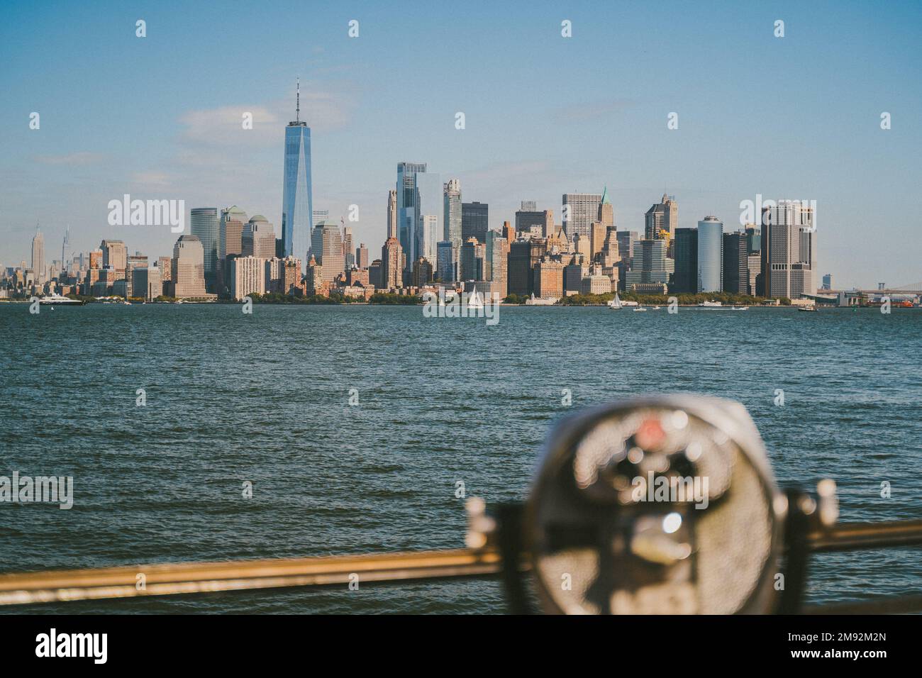 Jumelles modernes situées sur une plate-forme d'observation, près de la mer, avec des gratte-ciels dans la ville de New York sous un ciel bleu Banque D'Images