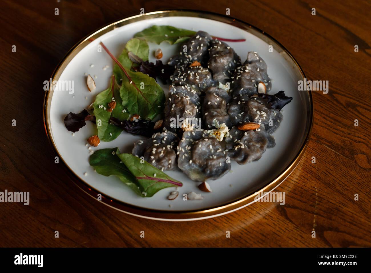 Un morceau de saumon grillé poivre citron et sel sur une assiette brune avec des feuilles de laitue. arrière-plan en bois. Photo de haute qualité Banque D'Images