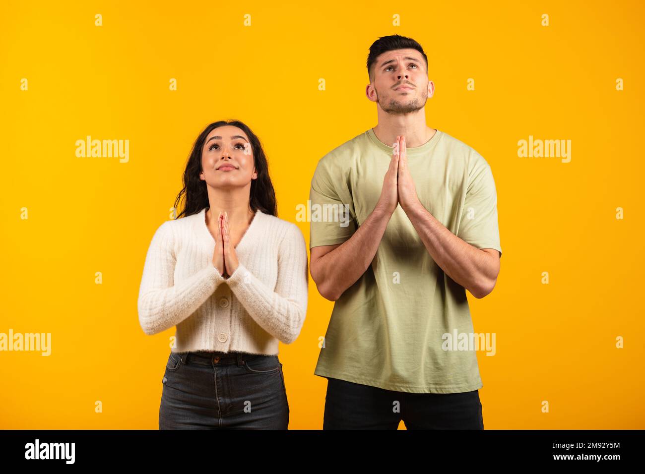 Le mari et la femme arabes du millénaire sérieux et concentrés se sont pliés les mains dans la supplication, faites le souhait, priez Banque D'Images