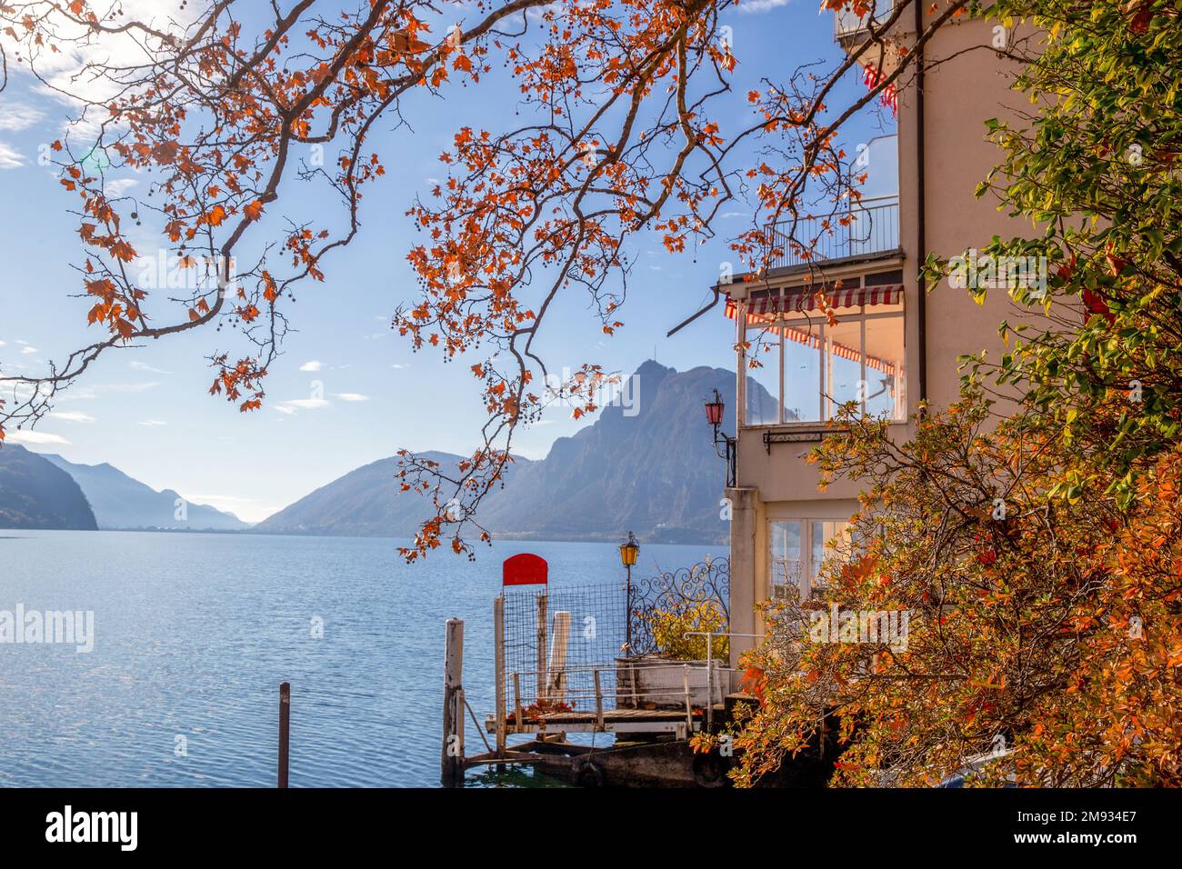 Vue incroyable depuis Olive Trail sur le lac de Lugano avec une feuille d'érable d'automne et un peu de brousse avec une couleur orange et un bâtiment Banque D'Images