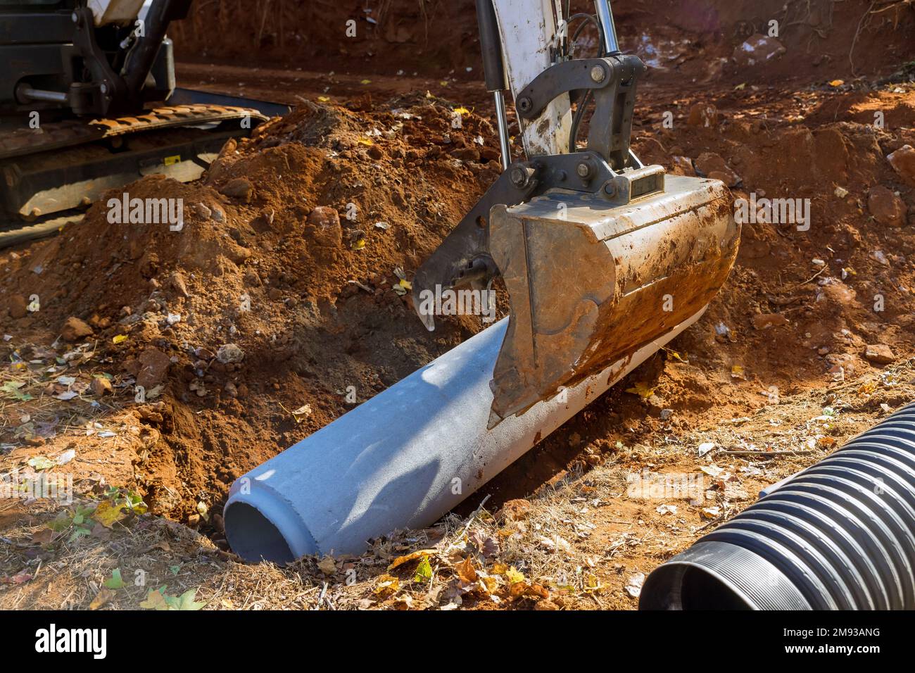 Les tuyaux d'égout en béton dans le sol pour pouvoir être installés sous terre utilisent le tracteur Banque D'Images