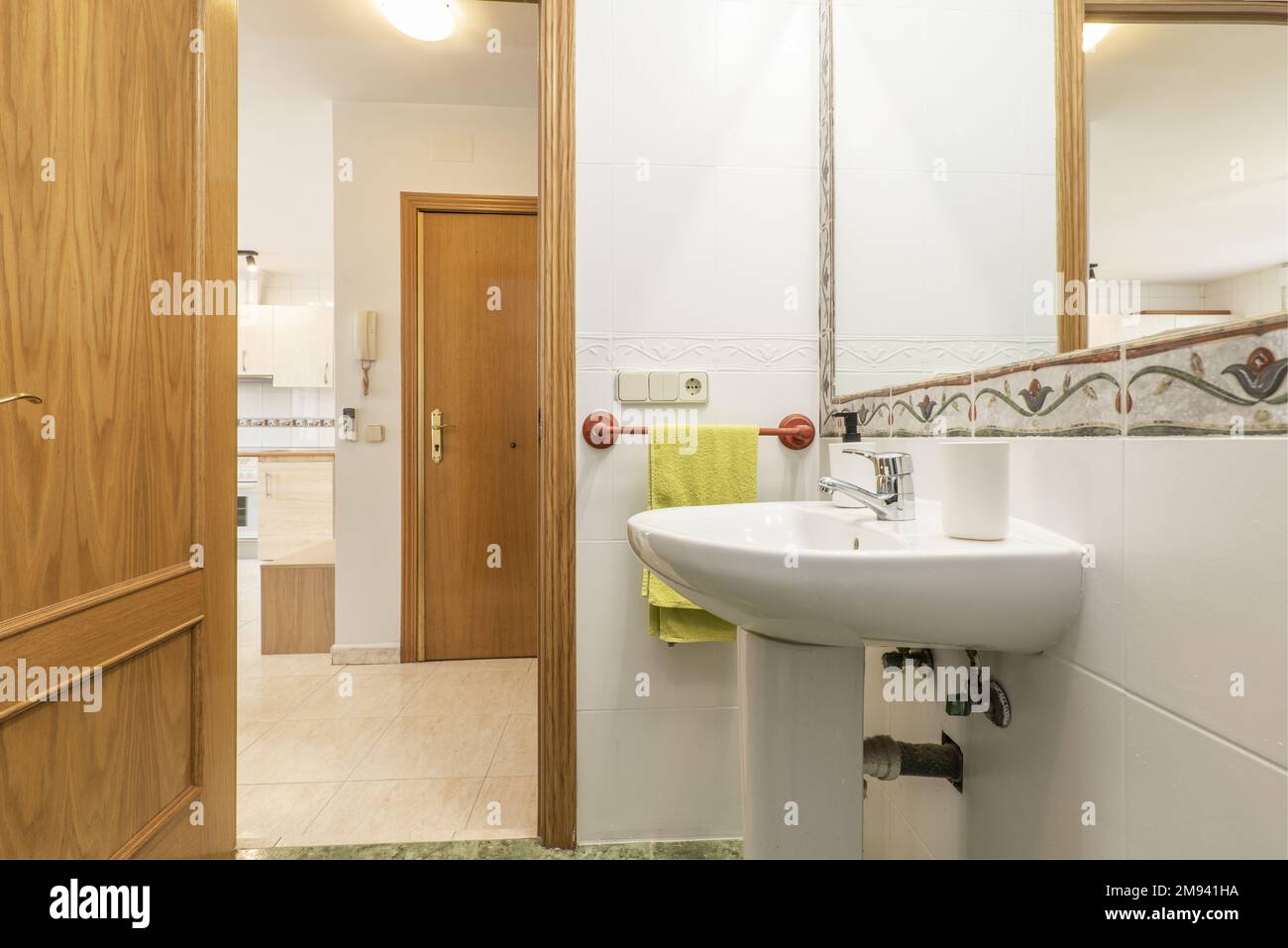 Salle de bains avec lavabo sur pied en porcelaine blanche d'une pièce et miroir mural avec cadre en cantonnière Banque D'Images