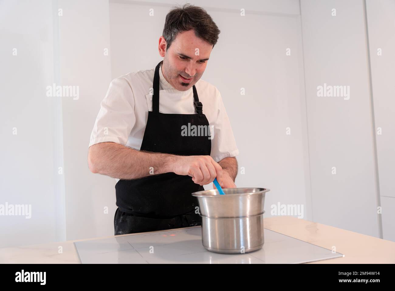 Un boulanger cuisant un gâteau de velours rouge à la maison, le cuisant dans un bain-marie, le travail à la maison Banque D'Images