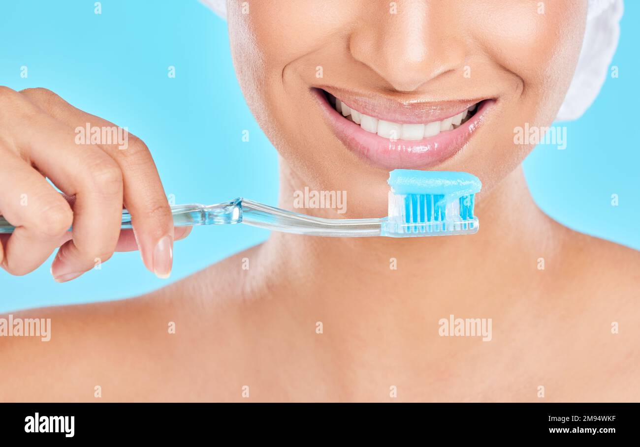 Prendre soin de ces dents. Photo en studio d'une jeune femme méconnue se brossant les dents sur un fond bleu. Banque D'Images