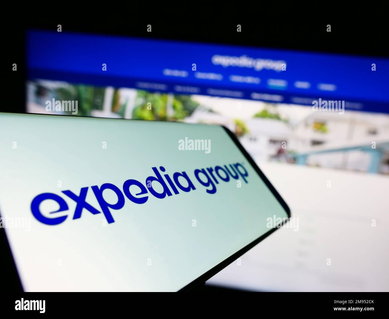 Téléphone portable avec logo de la société américaine de voyages en ligne Expedia Group Inc. À l'écran devant le site Web des affaires. Concentrez-vous sur le centre de l'écran du téléphone. Banque D'Images