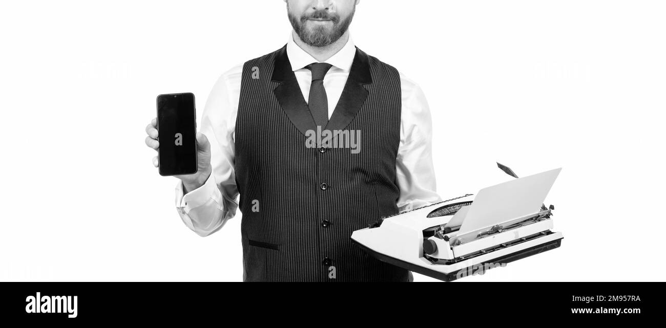 un homme court tient une machine à écrire rétro et un smartphone moderne, la technologie Banque D'Images