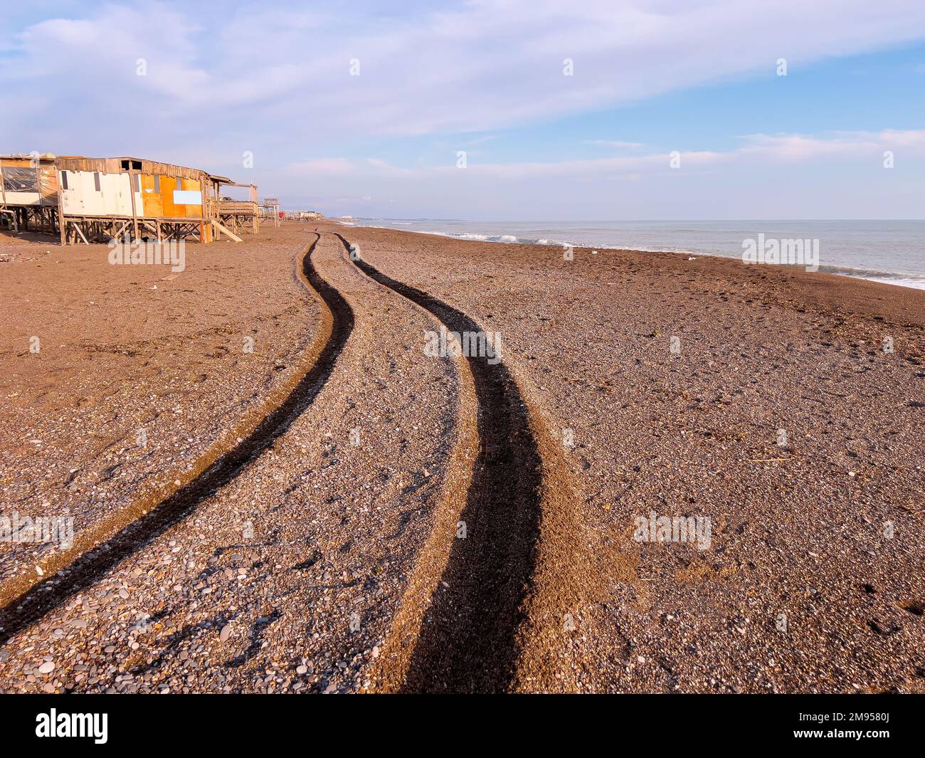 Piste de roue d'un 4x4 passant devant la plage au coucher du soleil Banque D'Images