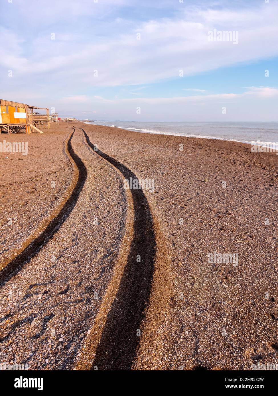 Piste de roue d'un 4x4 passant devant la plage au coucher du soleil Banque D'Images