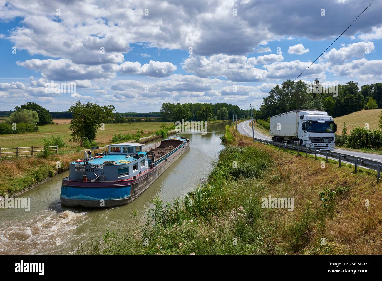 Péniche Freycinet le Paraguay transportant la terre de Paris sur le canal latéral a la Loire (canal parallèle à la Loire) et camion sur une route Banque D'Images