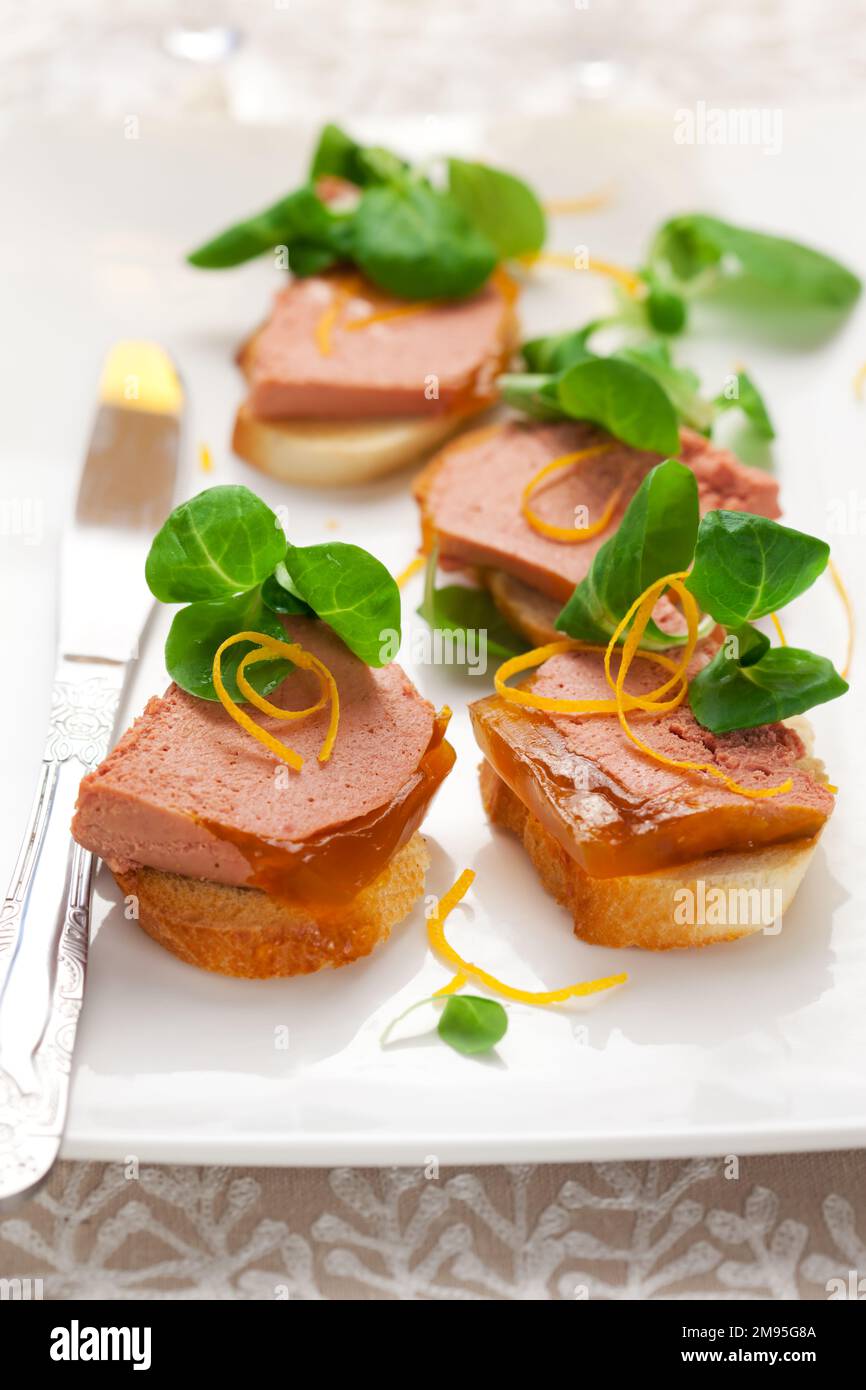 Délicieux hors-d'œuvre de Pâques pour le dîner de vacances. Pâté de foie de poulet avec gelée d'orange et salade de maïs frais sur un plat blanc. Banque D'Images