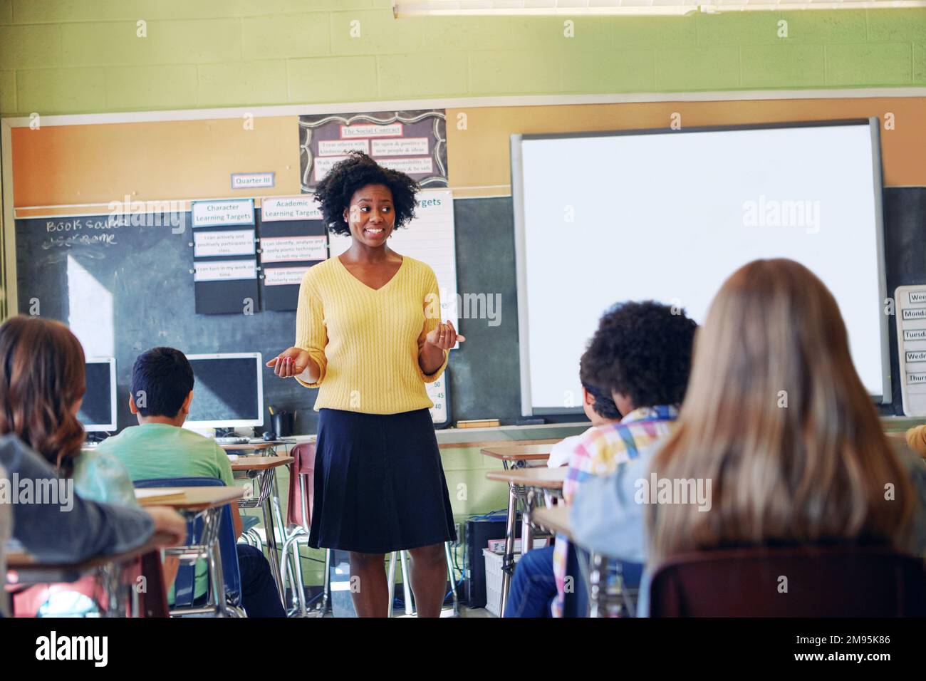 Femme africaine, enseignant et discussion en classe avec les élèves pour l'éducation, le soutien à l'apprentissage et le développement des connaissances. Bonne femme noire, préscolaire Banque D'Images