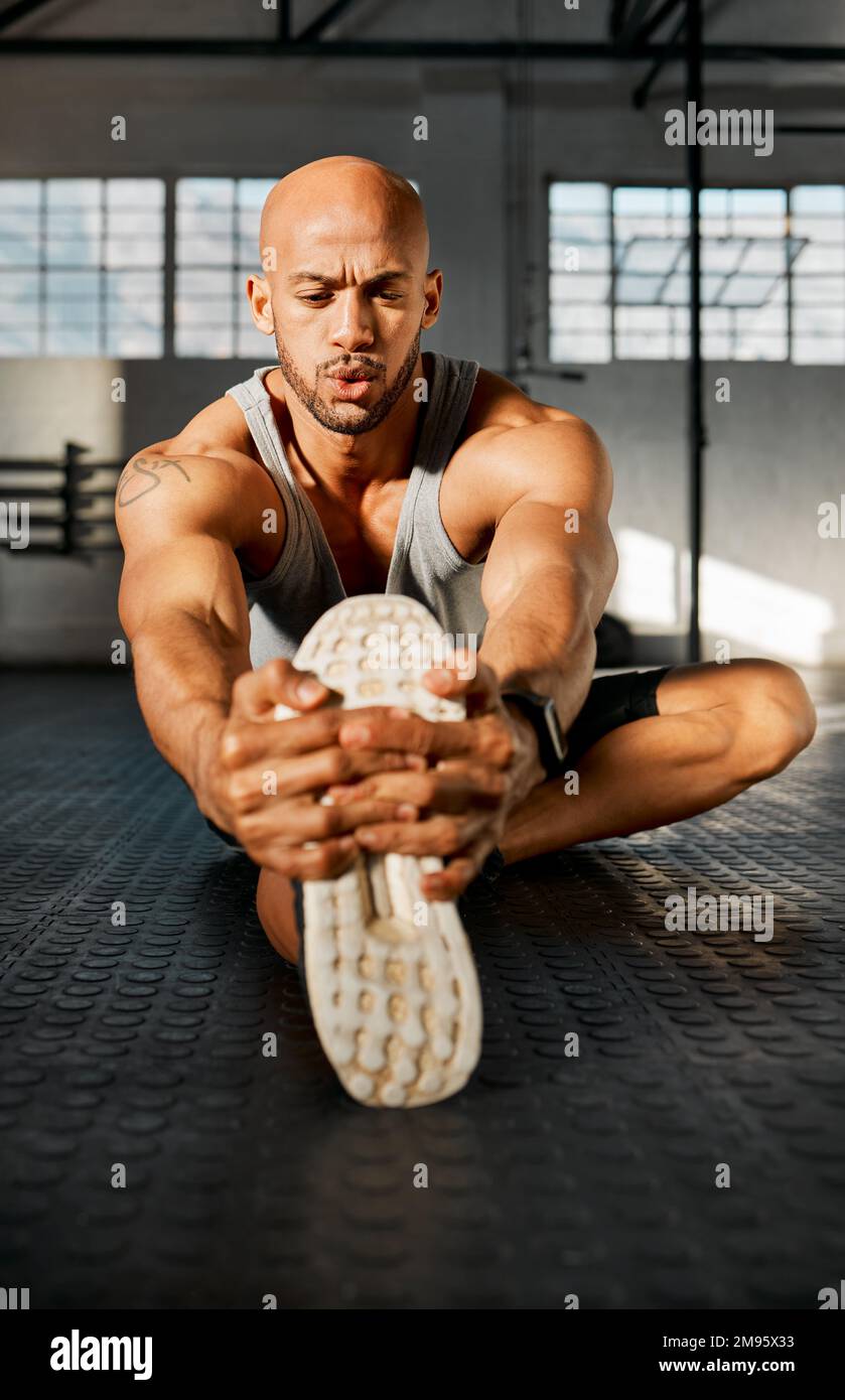 Ça ne me sentait pas fatigante. un jeune homme qui étire ses jambes avant un entraînement. Banque D'Images