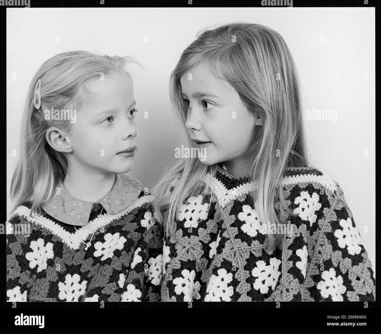 Sœurs jumelles non identiques portant des ponchos en crochet Banque D'Images