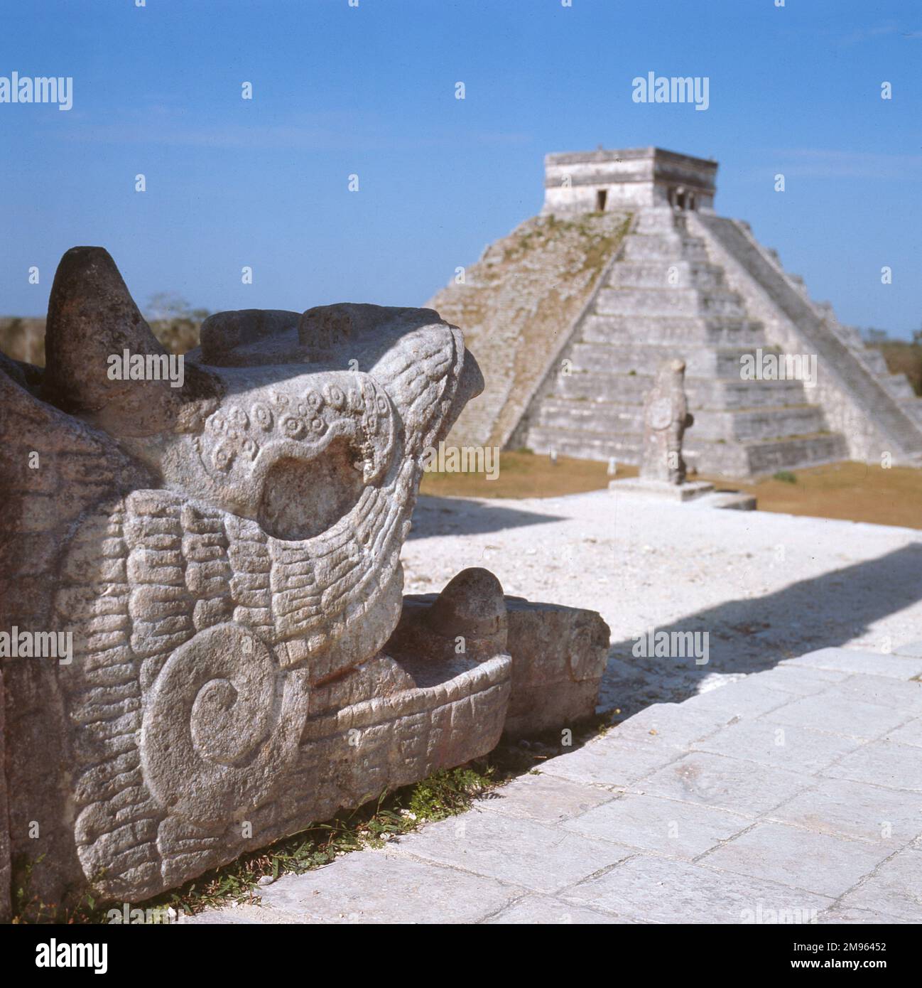 CHICHEN ITZA, YUKATAN. Une tête de serpent au temple des guerriers. En arrière-plan se trouve El Castillo, également connu sous le nom de la pyramide ou temple Kukulcan. Banque D'Images