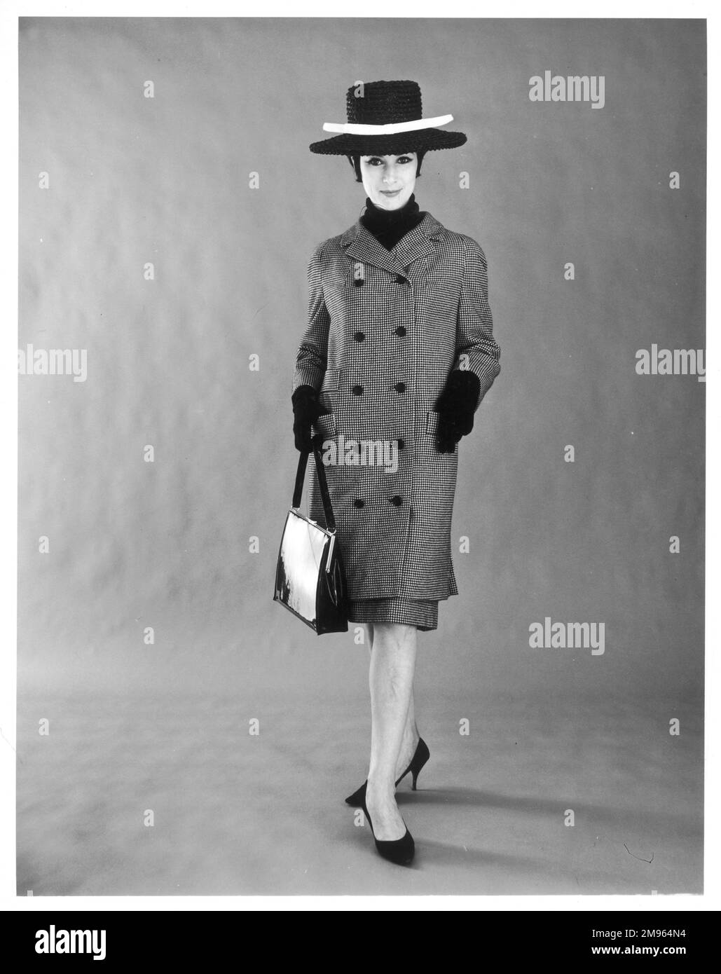Portrait complet d'une femme prête à sortir, portant son manteau, son chapeau et ses gants. Banque D'Images