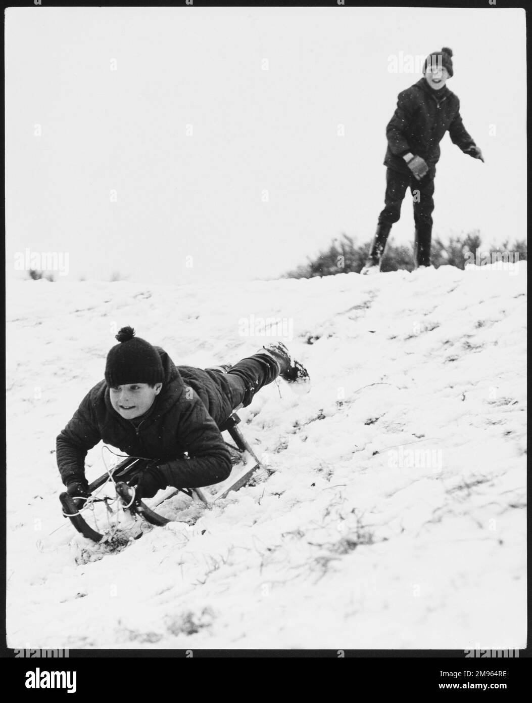 Deux garçons s'amuser et jouer avec leur traîneau dans la neige! Banque D'Images