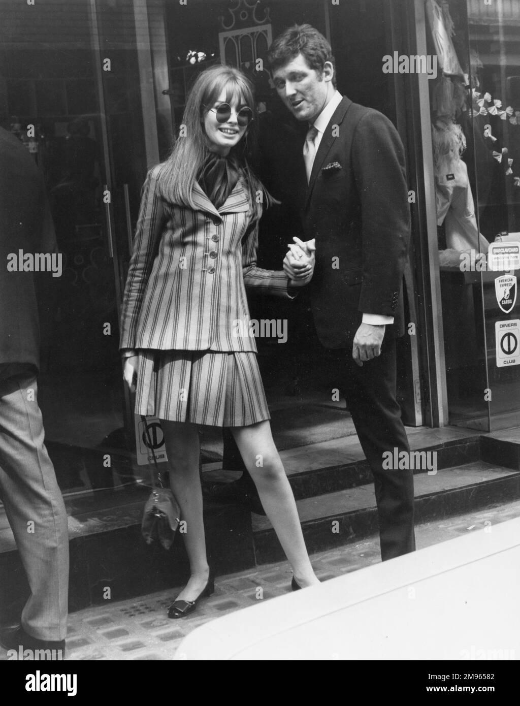 Un couple bien habillé magasiner sur Carnaby Street, le centre branché de Londres balançoire. Banque D'Images