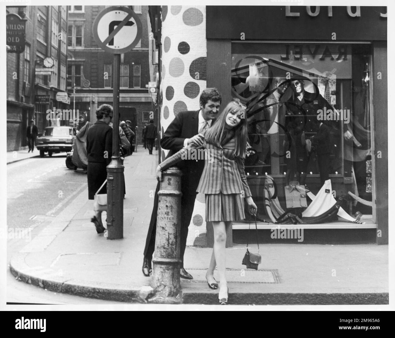Un couple bien habillé magasiner sur Carnaby Street, le centre branché de Londres balançoire. Banque D'Images