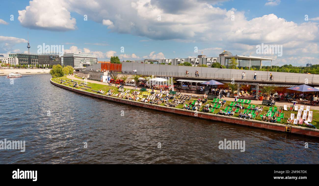 Berlin, Allemagne - 6 juillet 2011 : foules assises sur des chaises pliantes sur la rive herbeuse de la rivière Spree, jouissant de la vue de Berlin Hauptbahnhof et des s Banque D'Images Berlin, Allemagne - 6 juillet 2011 : foules assises sur des chaises pliantes sur la rive herbeuse de la rivière Spree, jouissant de la vue de Berlin Hauptbahnhof et des s Banque D'Images