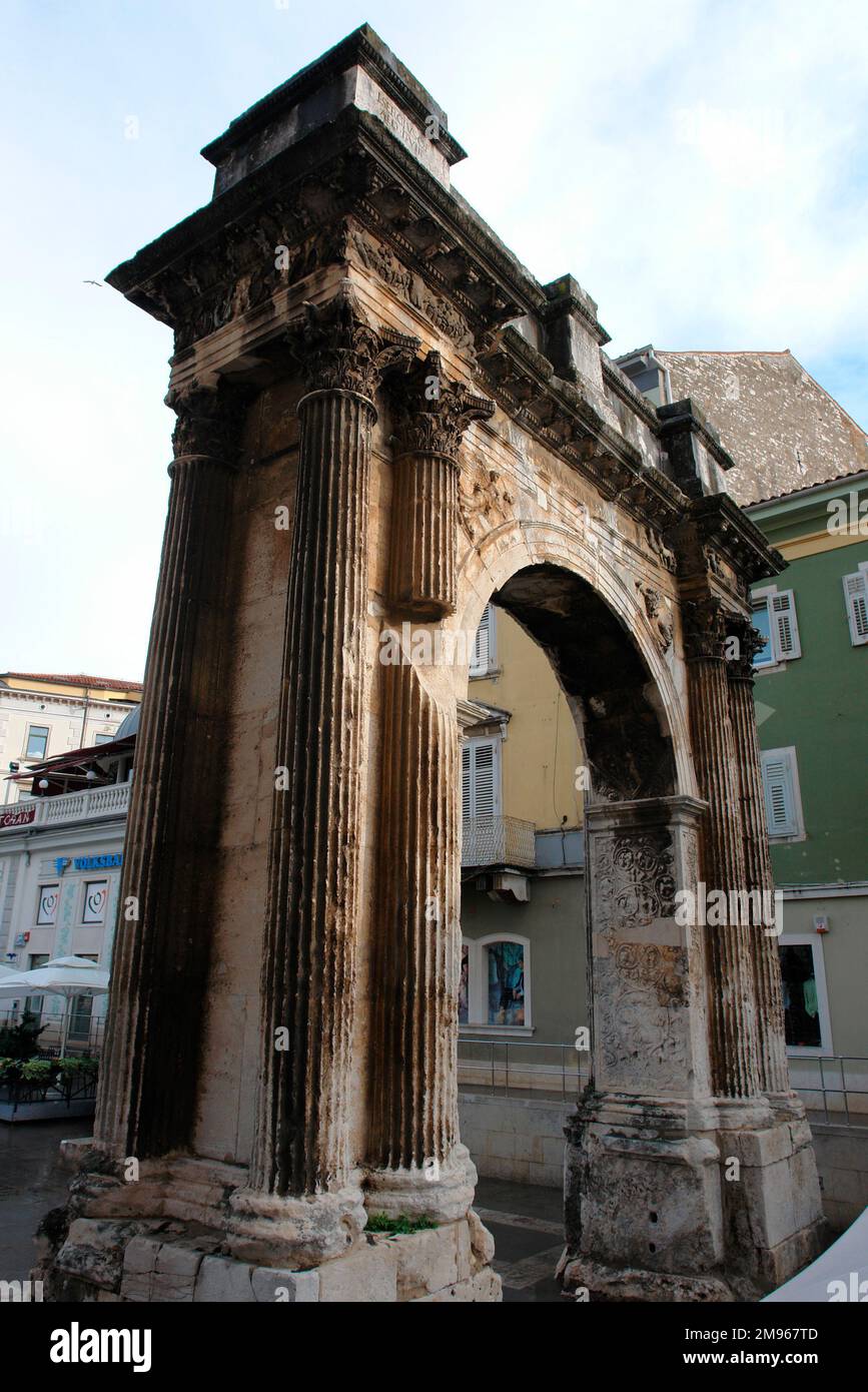 Vue latérale de l'arche triomphale du Sergii à Pula, sur la côte ouest de l'Istrie, Croatie. Cette ancienne arche romaine commémore trois frères de la famille Sergii, en particulier Lucius Sergius Lepidus, une tribune qui a combattu dans la bataille d'Actium. Il a été payé par la femme de Lepidus, Salvia Postuma Sergia, et a été utilisé à l'origine comme porte de ville. Banque D'Images