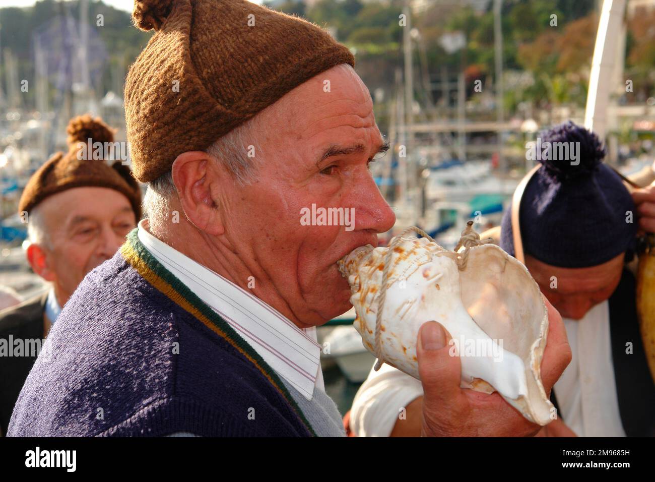 Homme appartenant à un groupe folklorique de Porto da Cruz, utilisant une coquille comme bugle. Il participe à des animations de rue à Funchal, la capitale de Madère. Banque D'Images