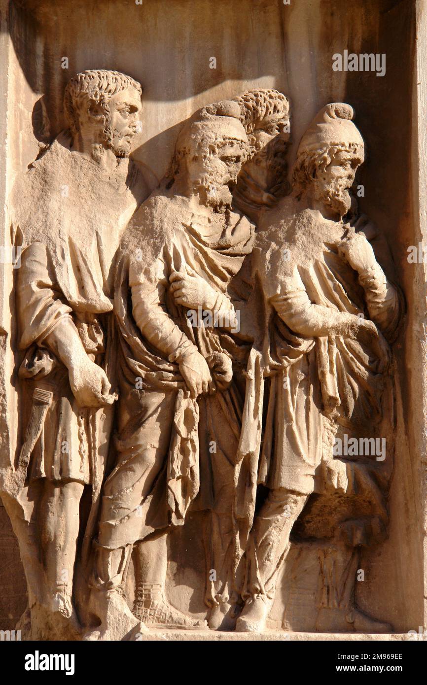 Détail d'une sculpture de bas relief sur l'Arche de Septimius Severus à Rome, Italie, représentant la livraison de quatre prisonniers de guerre. Il s'agit d'une arche triomphale en marbre blanc dans le Forum romain, dédiée en 203 à la commémoration des victoires parthiennes de l'empereur Septimius Severus et de ses deux fils, Caracalla et Geta, dans les deux campagnes contre les Parthiens. Banque D'Images