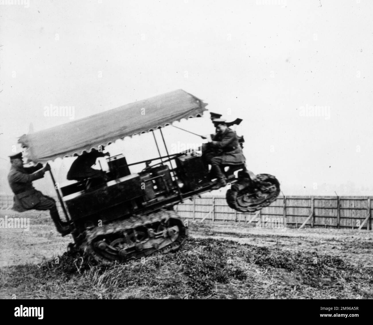 Les soldats testent sur le terrain un nouveau véhicule à chenilles pendant la première Guerre mondiale -- il ne semble pas être très stable sur un sol inégal. Banque D'Images
