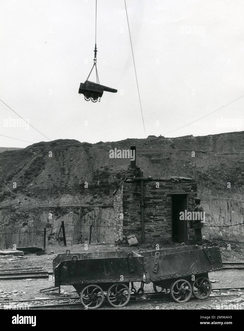 Un tramway plein d'ardoise, en hauteur dans l'air, étant lentement abaissé au sol à Penyrorsedd Slate Quarry, Nantlle Valley, Caernarvonshire (maintenant Gwynedd), au nord du pays de Galles. De là, l'ardoise sera transportée jusqu'aux hangars. Banque D'Images