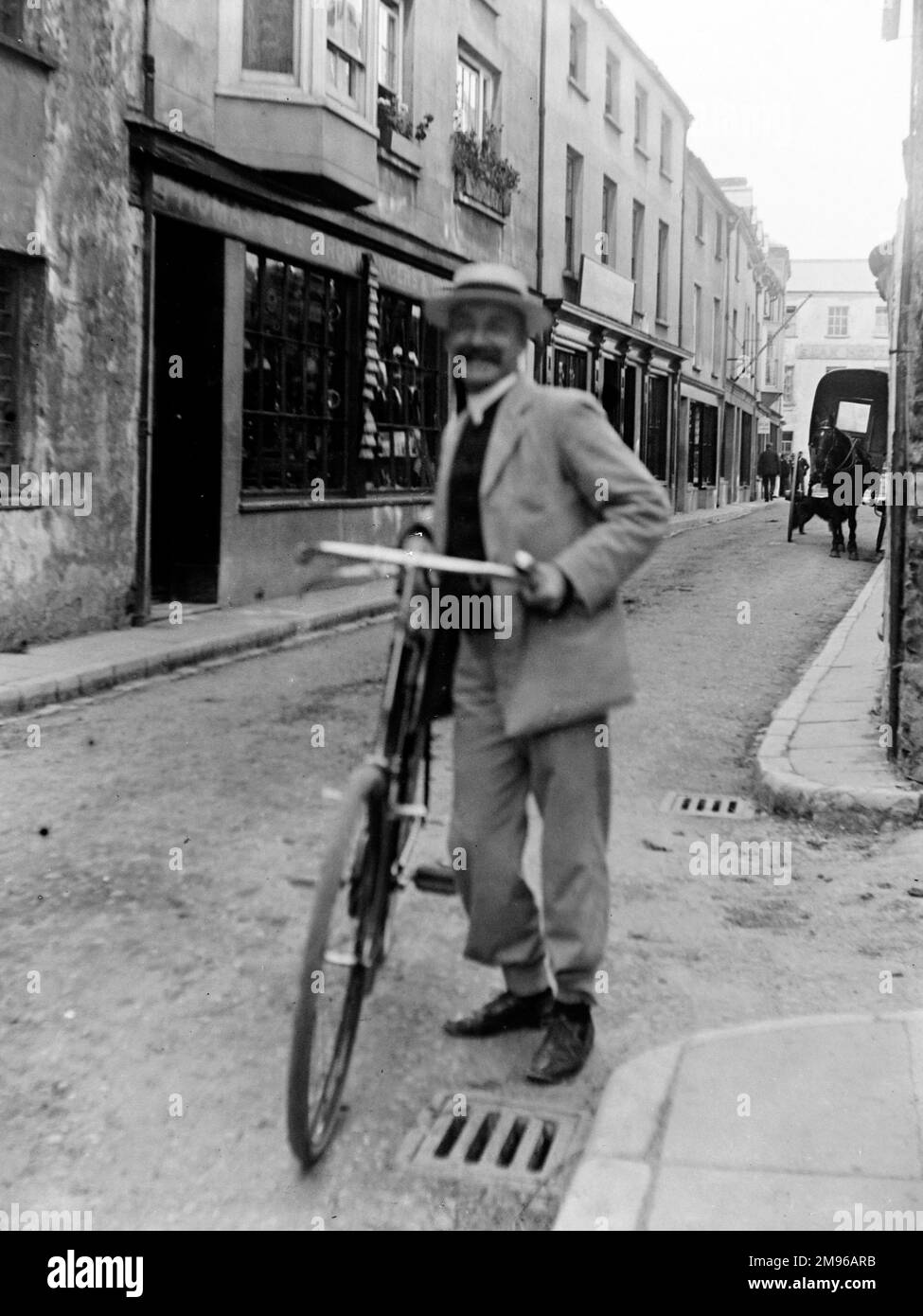 Un cycliste avec son vélo sourit à la caméra de Bridge Street, Haverfordwest, Pembrokeshire, Dyfed, au sud du pays de Galles. Banque D'Images