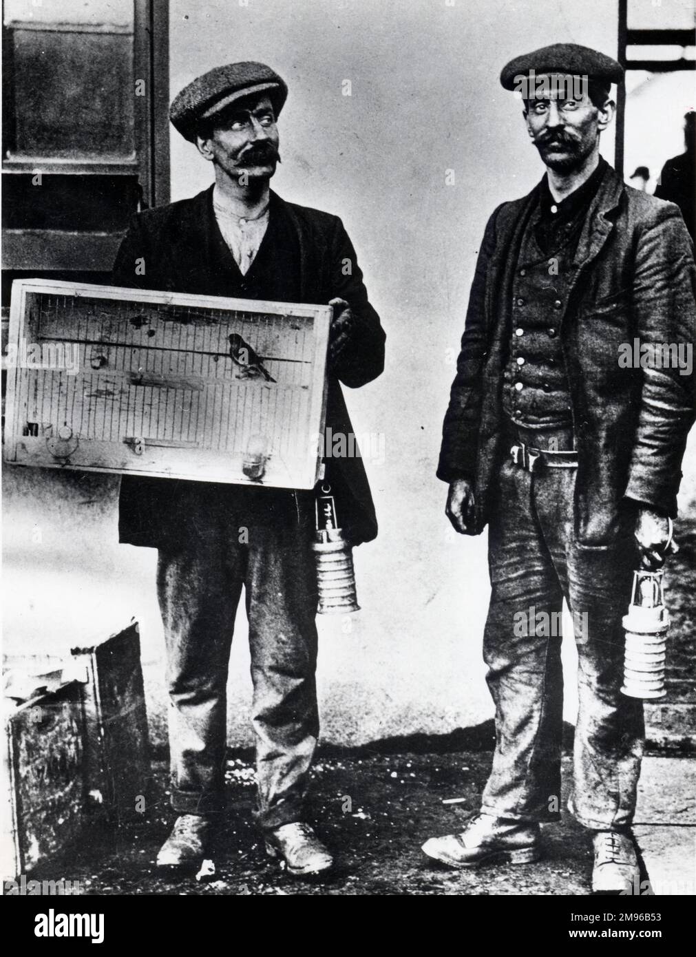Deux mineurs à la mine de charbon Universal Pit, Senghenydd, près de Caerphilly, Glamourgan, pays de Galles du Sud, avec un canari en cage qui a été utilisé pour tester l'air pour le gaz, ou manque d'oxygène. Les hommes portent les premières versions de la lampe de sécurité d'huile. Banque D'Images