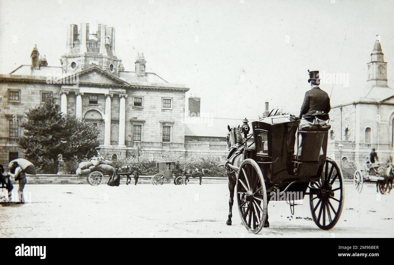 Une scène de rue victorienne tardive avec une calèche tirée par des chevaux au premier plan, et divers autres véhicules tirés par des chevaux au loin. Banque D'Images