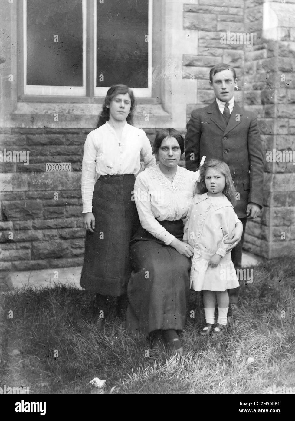Une mère et ses trois enfants qui ont l'air plutôt glum, au centre du pays de Galles. Banque D'Images