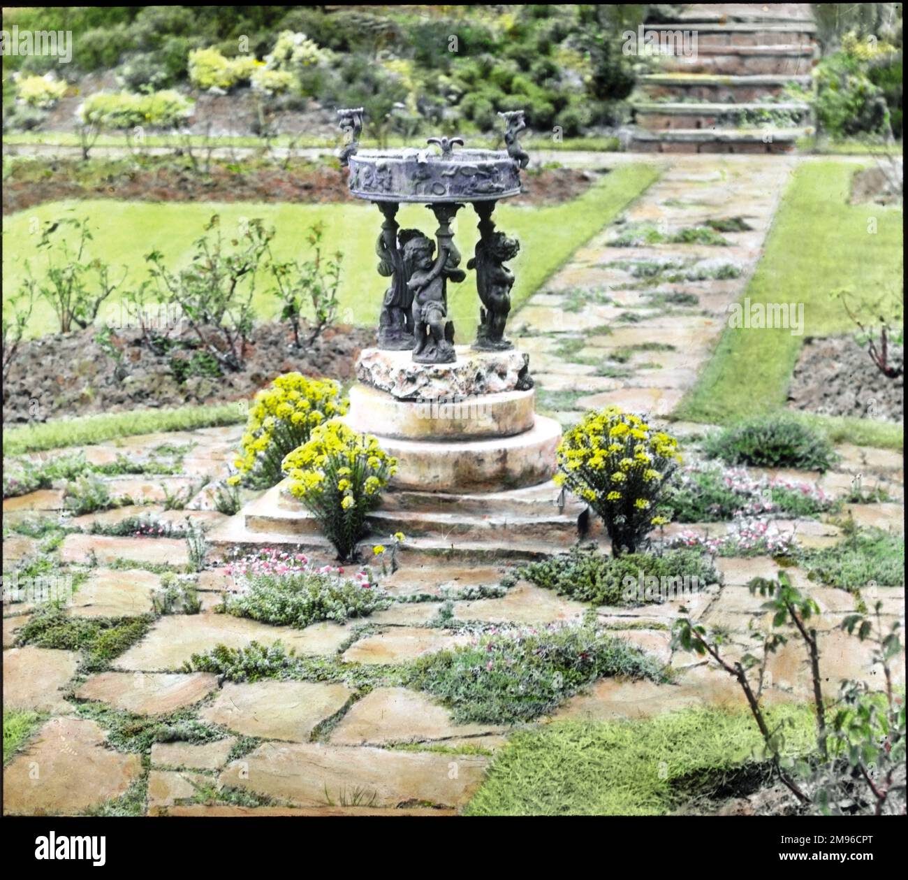 Vue sur un jardin à Heronden, Tenterden, Kent. Un bain d'oiseaux ornemental est au centre, avec des chemins, des parterres et de l'herbe autour. Banque D'Images