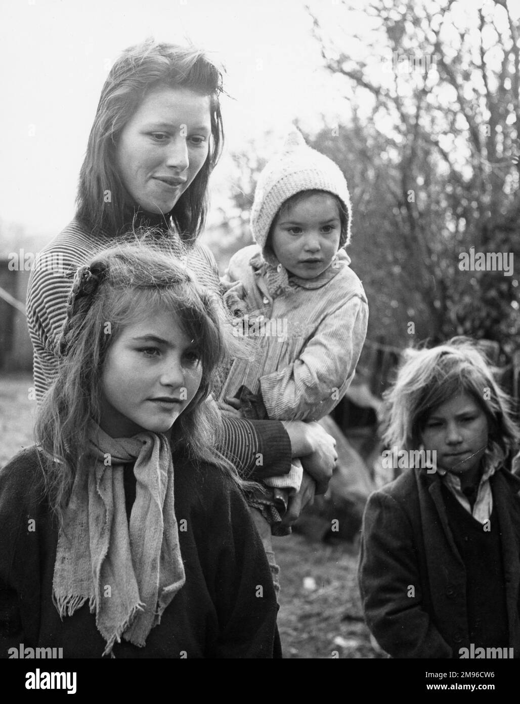 Une famille tzigane dans un campement de Surrey -- une jeune mère et ses trois enfants. Banque D'Images
