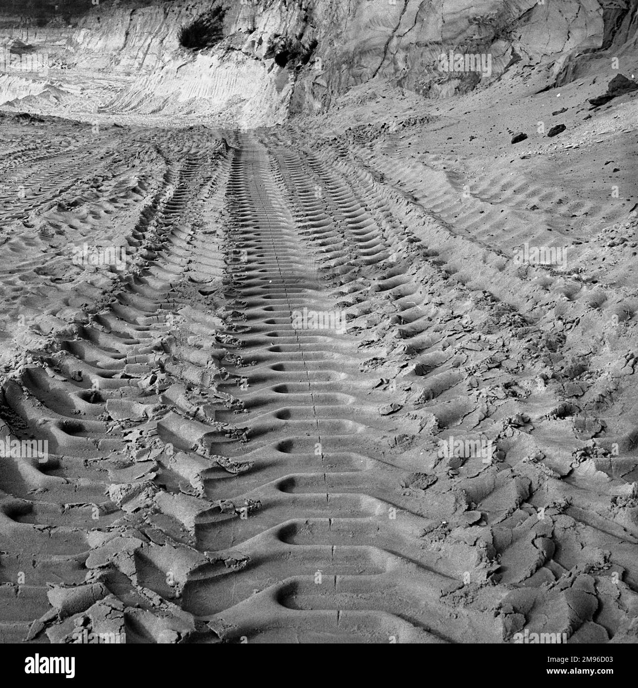 Un motif intéressant est laissé par les pistes d'un véhicule sur une plage de sable. Banque D'Images