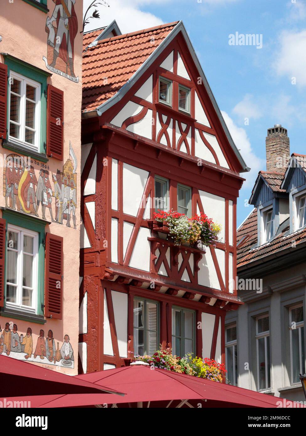 Vue sur l'hôtel Zum Karpfen, maison à pans de bois, dans la ville d'Eberbach, Bade-Wurtemberg, Allemagne. Les peintures sur la façade (à gauche) illustrent l'histoire de la ville. Banque D'Images