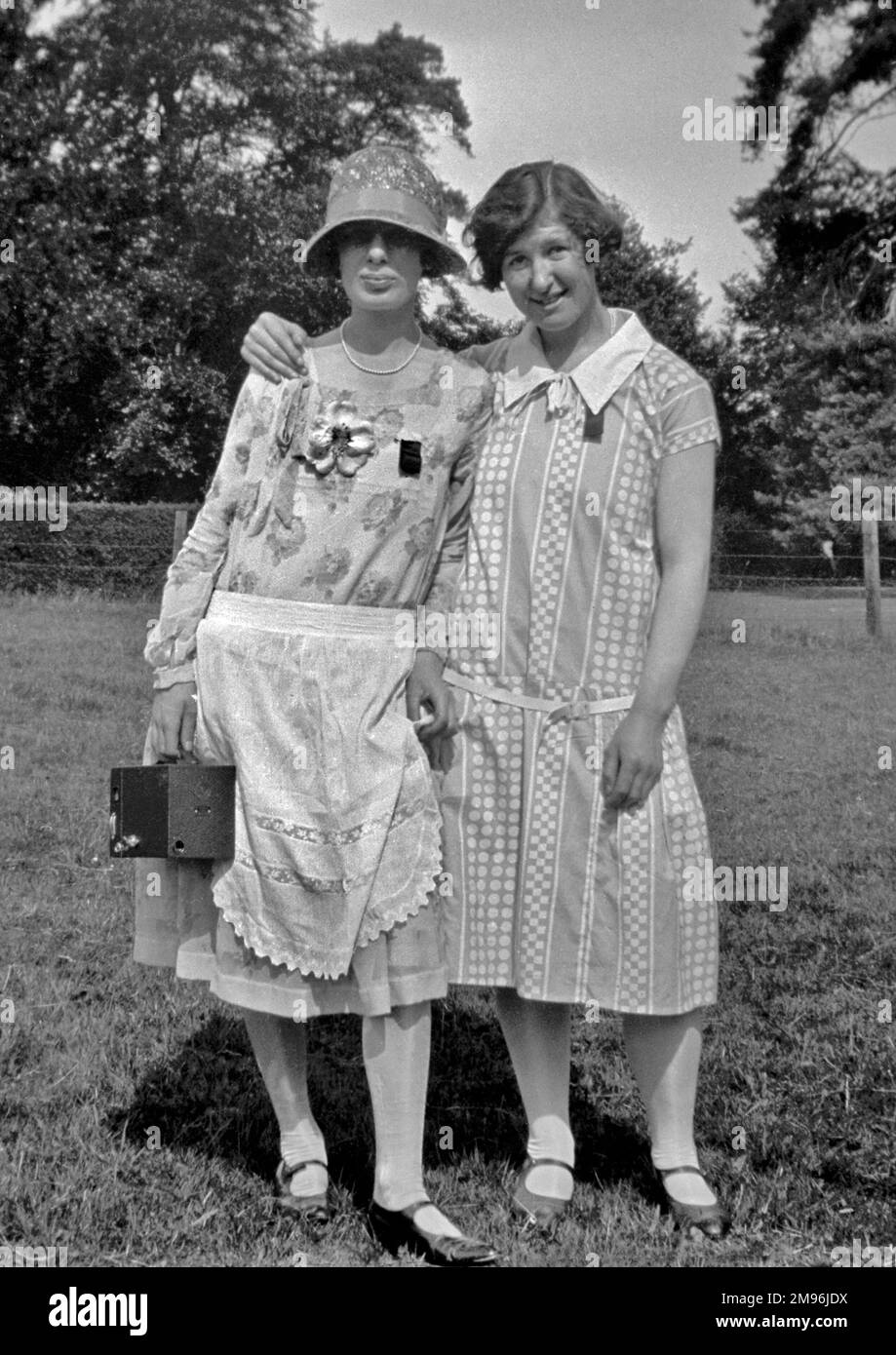 Deux femmes dans leurs meilleurs vêtements, posant pour leur photo dans un champ. Banque D'Images