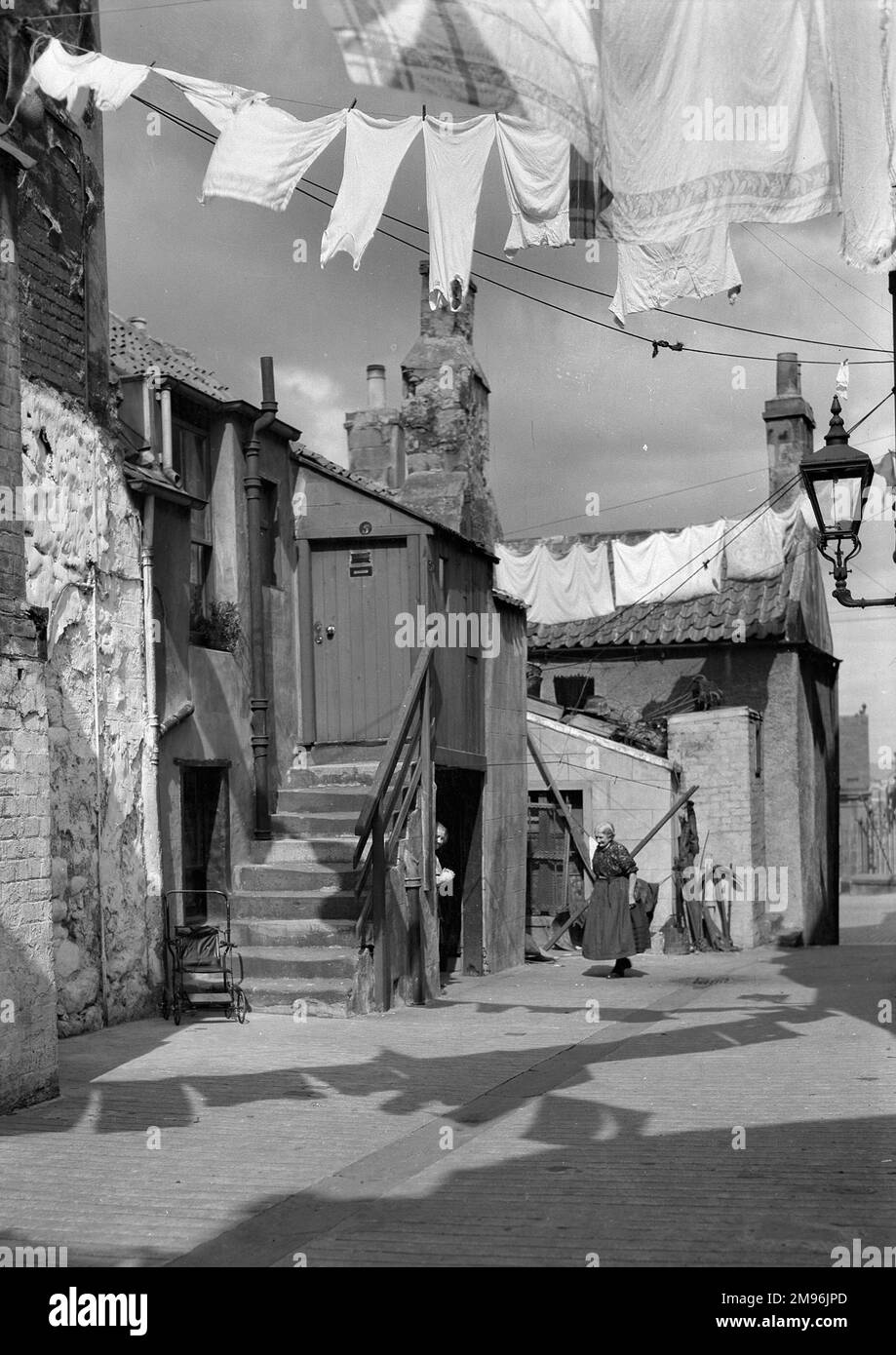 Une scène de rue d'Édimbourg, montrant deux voisins âgés bavardant au soleil le jour du lavage. Banque D'Images