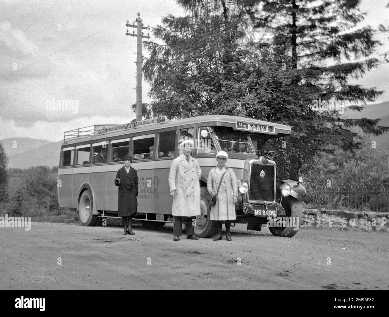 Un bus de Glasgow à Oban, avec équipage et passagers, sur une route de campagne quelque part en Écosse. Banque D'Images