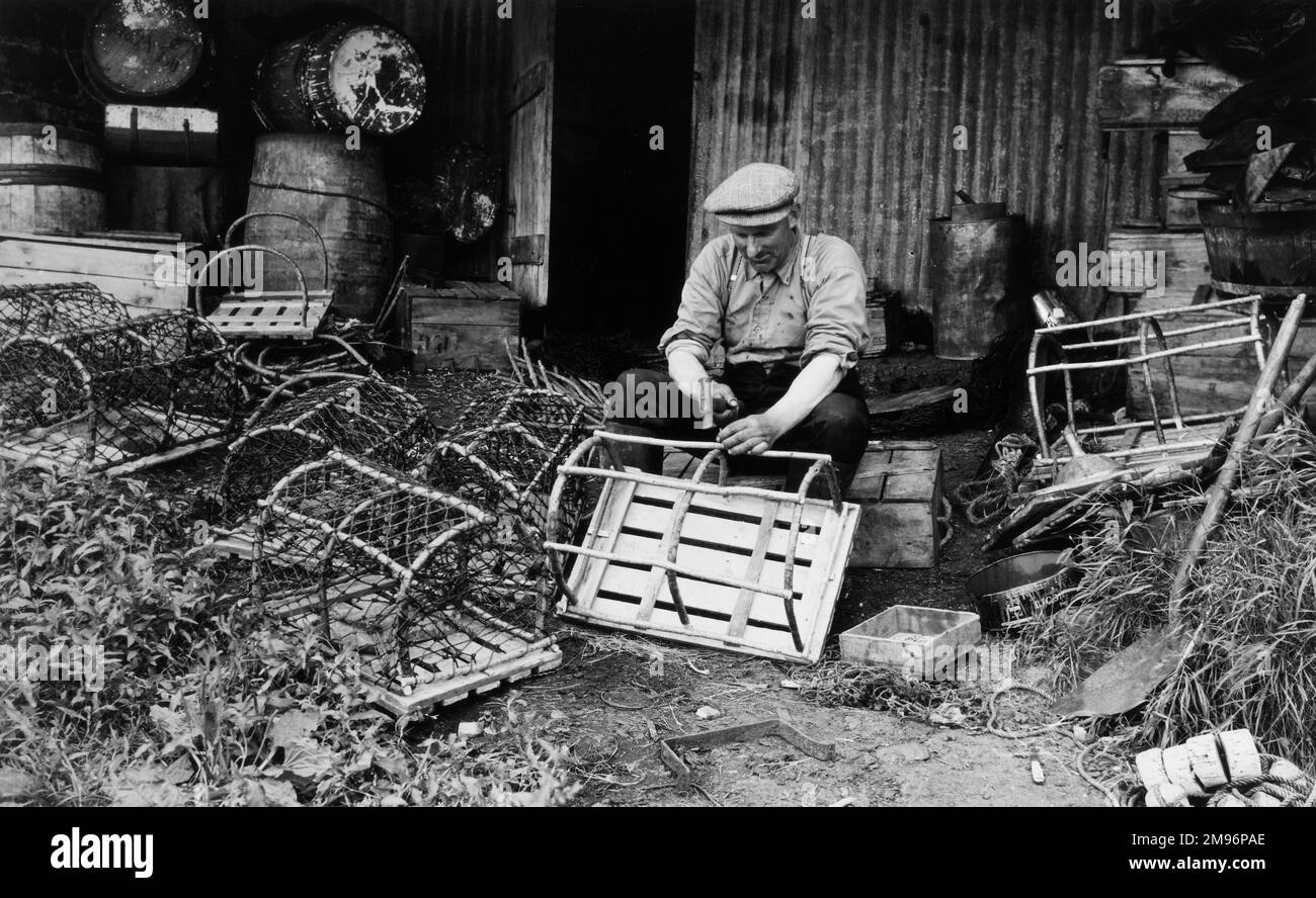 Un pêcheur qui fait et répare des pots de homard. Banque D'Images