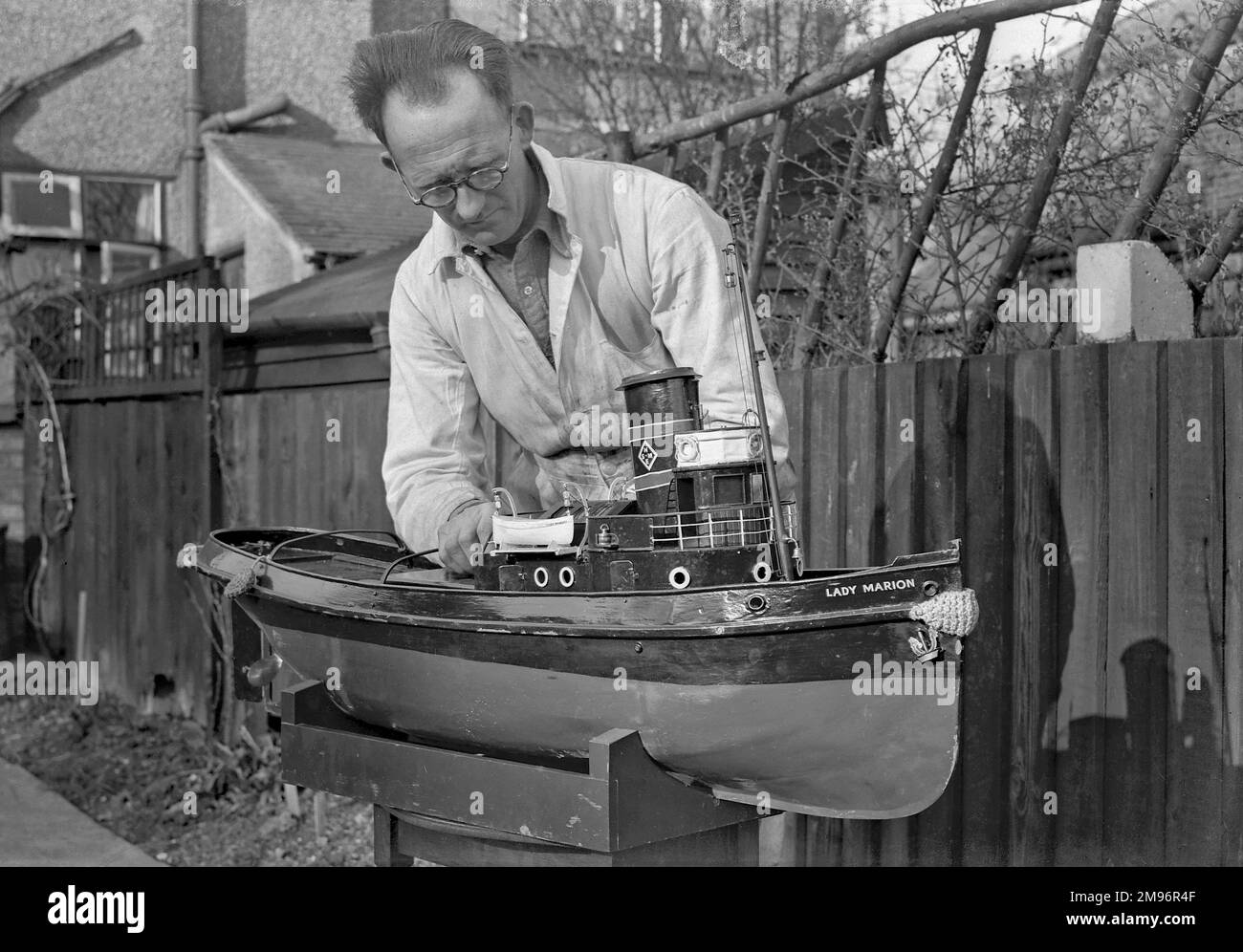 Un homme qui fait un bateau modèle, Lady Marion, dans un jardin à l'arrière. Banque D'Images