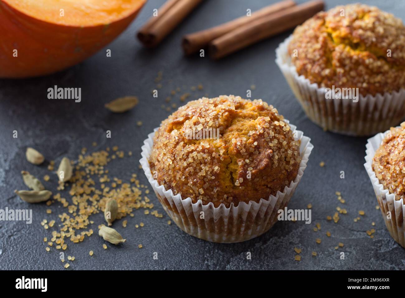 Délicieux muffins à la citrouille maison avec croûte de sucre épicée et lait sur fond noir texturé, espace Banque D'Images