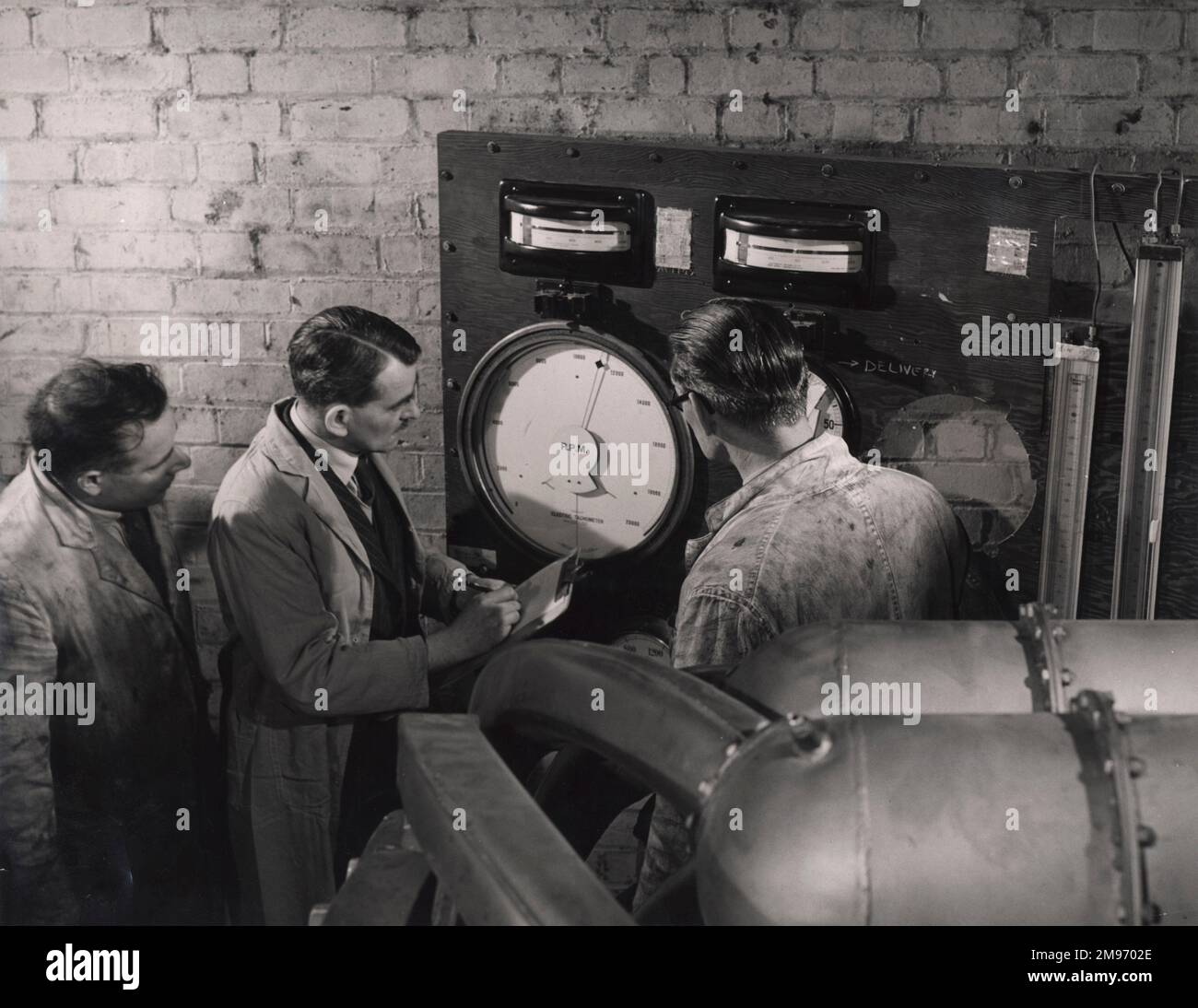 « Sir Frank Whittle (au centre) et ses associés expérimentent avec une première turbine à gaz dans une fonderie désaffectée de Lutterworth. Une scène du film COX "The Wonder Jet". Produit par l'unité du film de la Couronne pour l'unité d'information économique, ce film raconte l'histoire passionnante de l'une des merveilles de ce siècle : la turbine à gaz à propulsion par jet. C'est une histoire de pionnier et de réussite britannique. Il y a vingt-cinq ans, la turbine à gaz n’existait pas, elle est aujourd’hui un facteur vital dans la lutte de la Grande-Bretagne pour la prospérité. » Banque D'Images