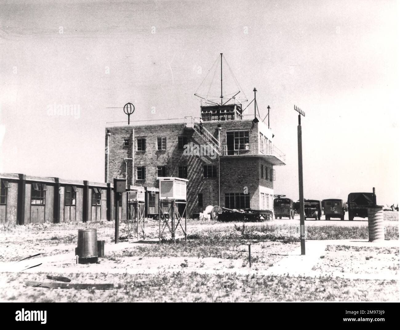 La tour de contrôle du côté nord a été construite par la RAF sur des lignes militaires familières. Dans cette vue de 1945, on peut voir un RAF Anson et plusieurs véhicules militaires de ravitaillement, ainsi que les préfabs qui hébergeaient le personnel de l'aéroport. Des opérateurs météorologiques, téléimprimeurs et radiophoniques étaient basés dans les bâtiments adjacents à la tour de contrôle. Banque D'Images