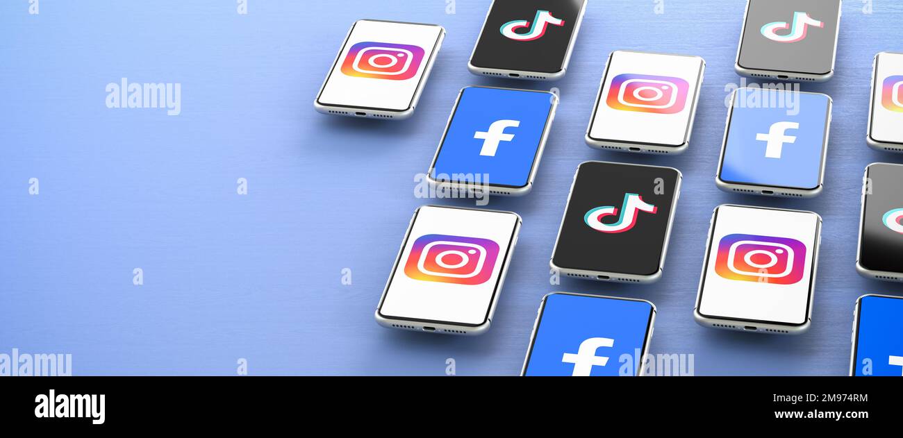 Concept de médias sociaux : logos des plates-formes de médias sociaux Facebook, Instagram et TikTok affichés sur les smartphones survolant une table bleue. Banque D'Images