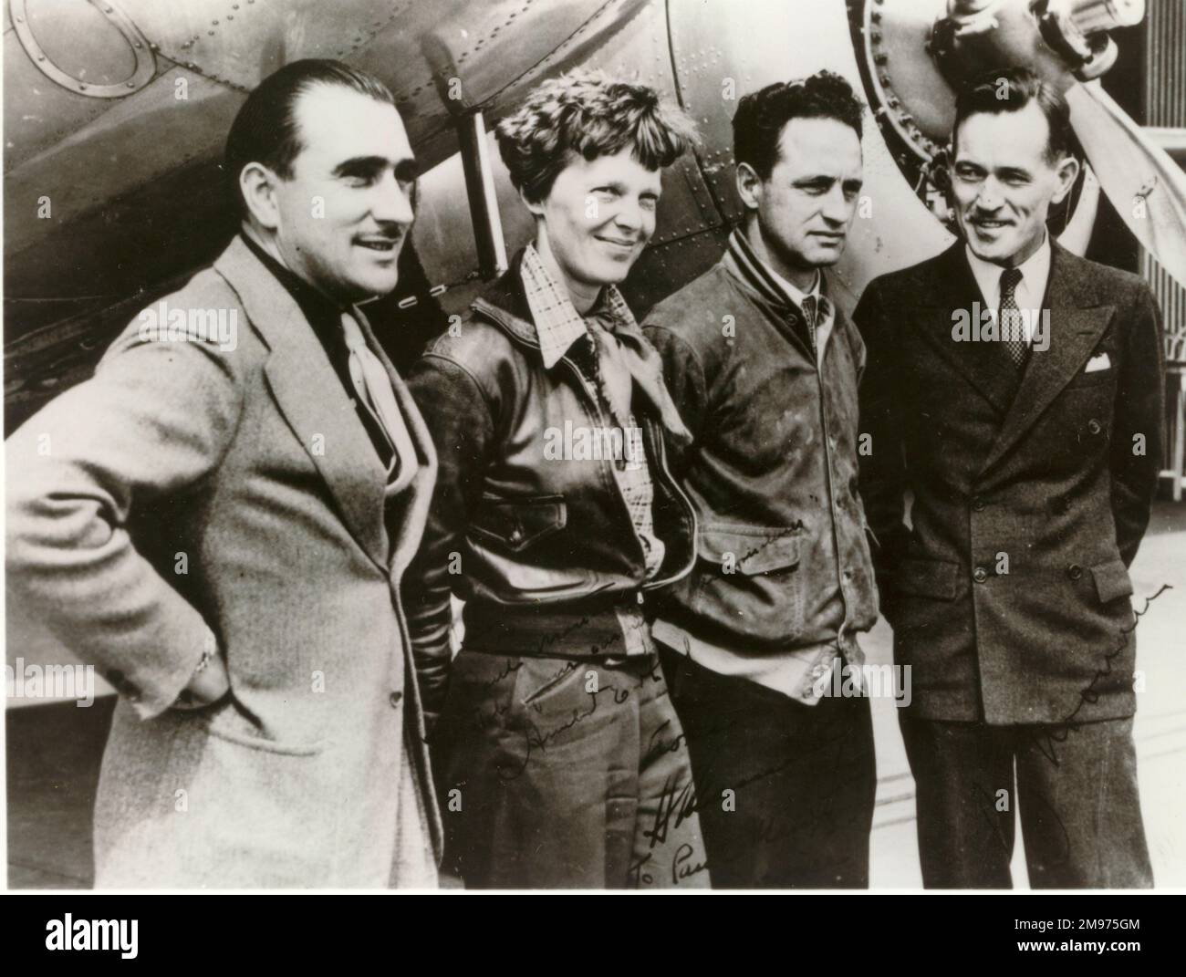 Photo Autographiée d'Amelia Earhart et de son équipage aux côtés de leur Lockheed Electra en 1937 avant de partir d'Oakland, Californie, pour la société automobile. De gauche à droite : Paul Mantz, Amelia Earhart, Harry Manning et Fred Noonan. Banque D'Images
