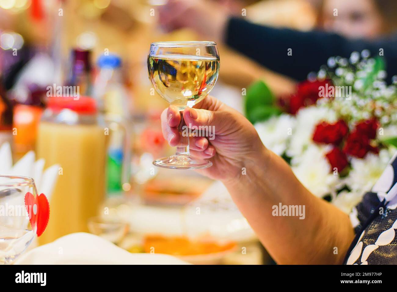 mains d'une femme avec un verre de vin blanc en gros plan Banque D'Images